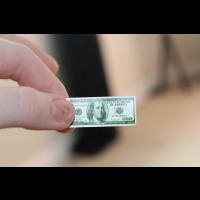 Photo main qui tient un billet de faux dollar. Image par neonlizard de Pixabay